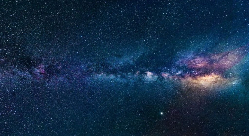 Capture of the Milky Way galaxy stretching across the dark night sky, filled with stars.